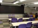 View of tables, chairs, and blackboard.