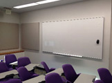 Picture of white board and purple chairs