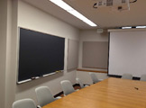 Picture of the side of the room with a long table and whiteboard