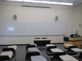 Photo of locy Hall Room Number 214 showing a whiteboard and some chairs