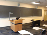 View of blackboard, podium, and table in the front of the room.