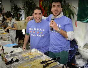 Two international students handing out food during the Law School's Global Village event