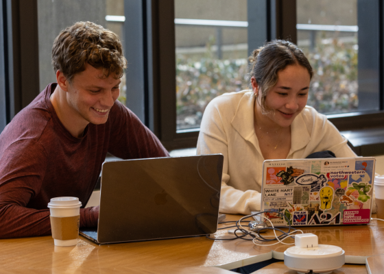two students working on their laptops