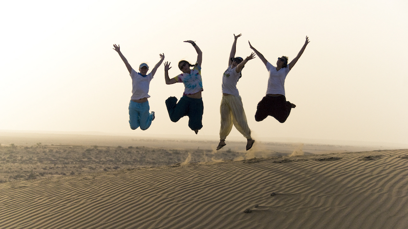 Students jumping in a desert in India