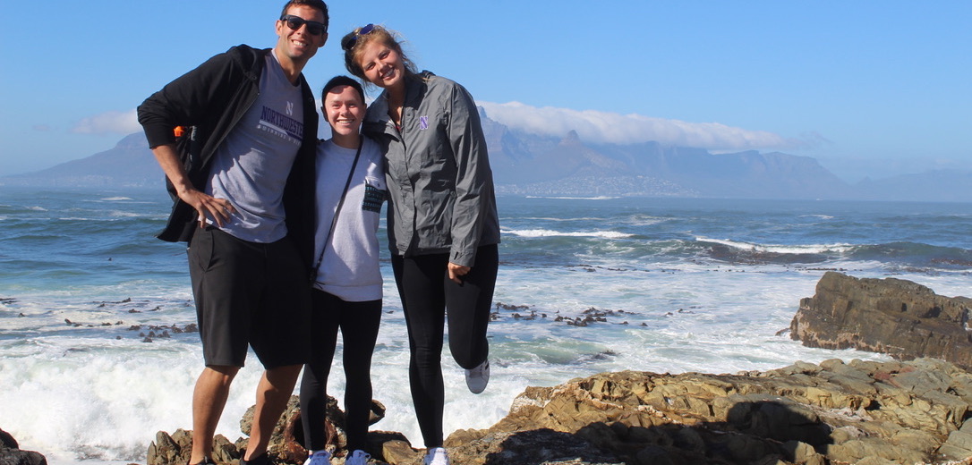 Student and friends posing on the rocks overlooking the coast of South Africa