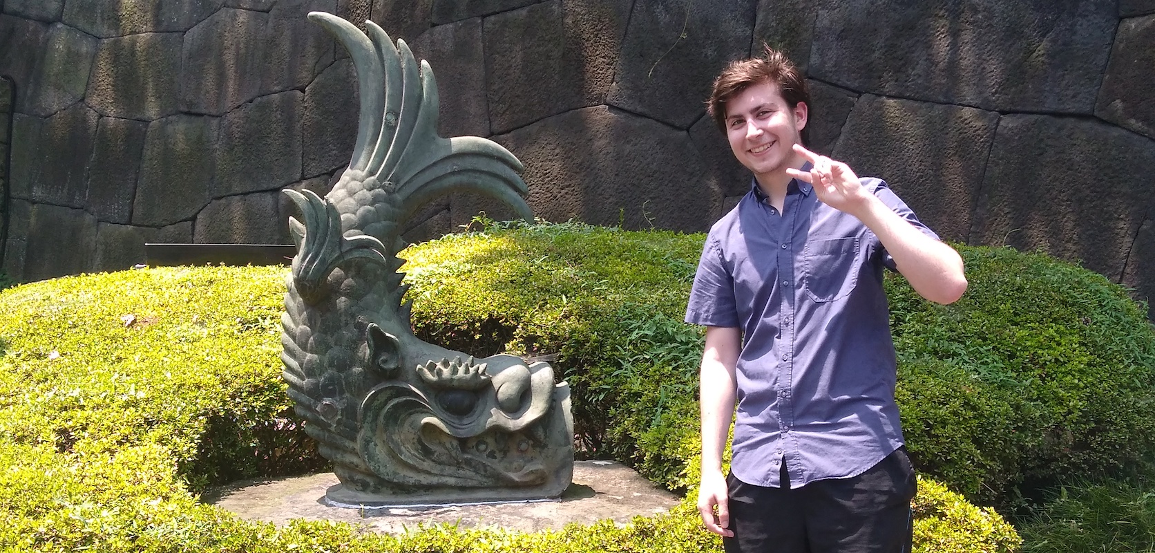 Student posing beside sculpture while studying abroad in Japan