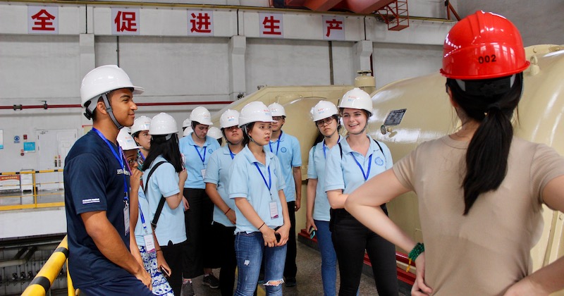 Students in hard hats tour clean energy facility in Hangzhou, China
