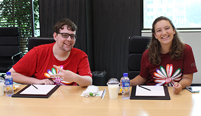 Two smiling students at a registration desk