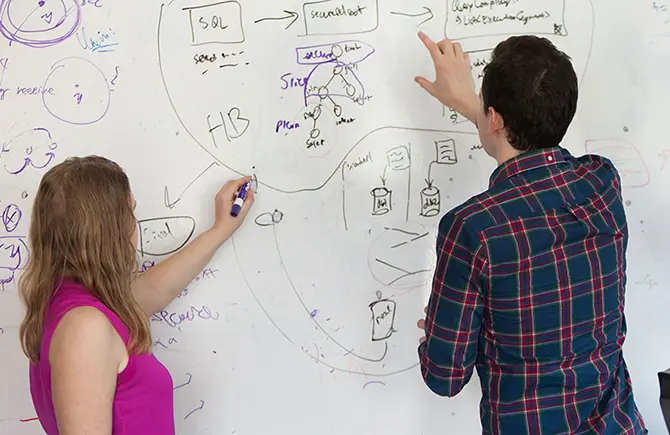 students working out problem on whiteboard
