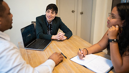 Gender neutral person leads a meeting with colleagues