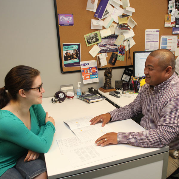 student with advisor at desk