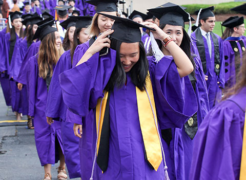 Student adjusting her cap at Commencement