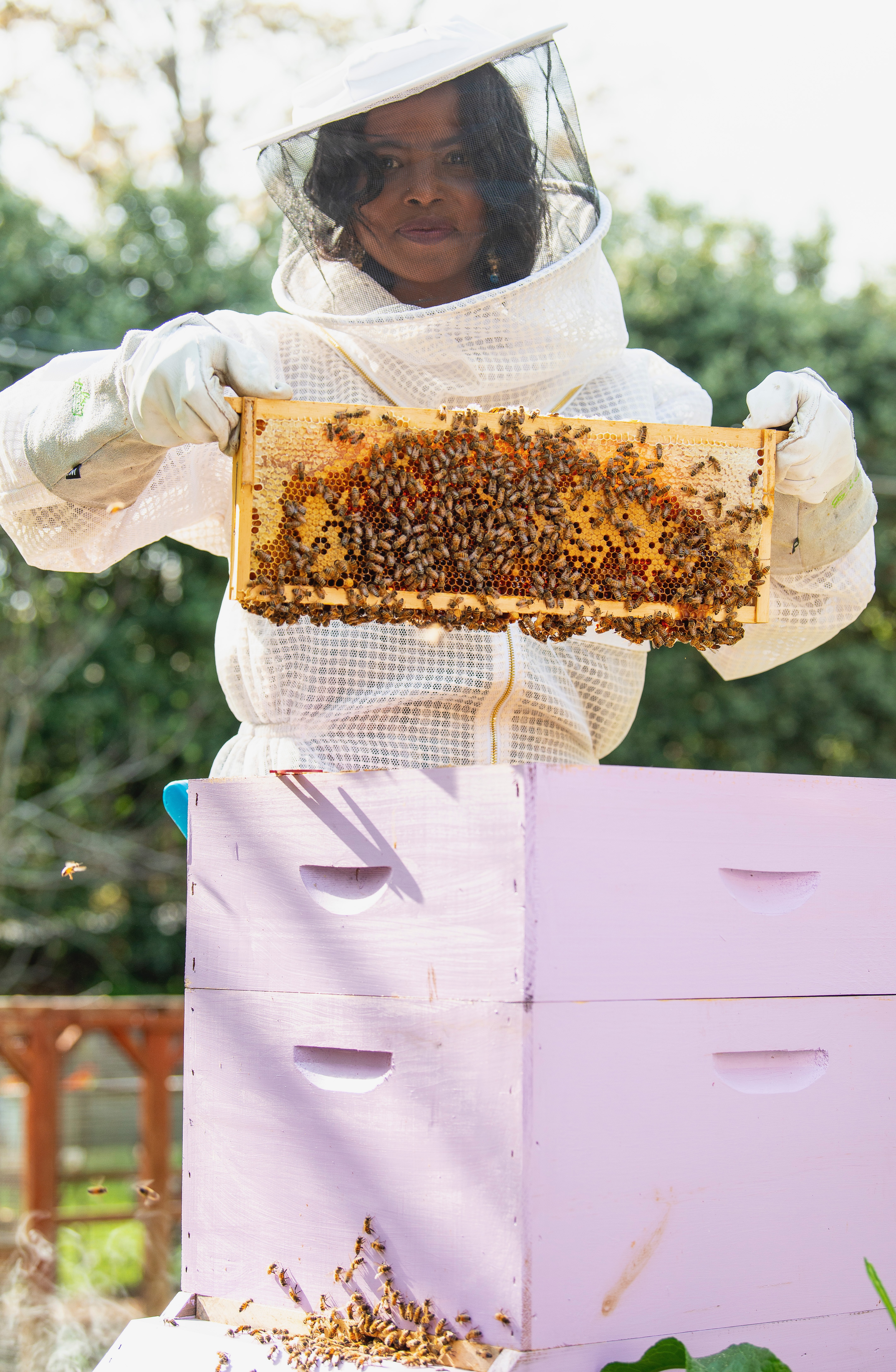Photo of Michelle Johnson in bee keeper suit.