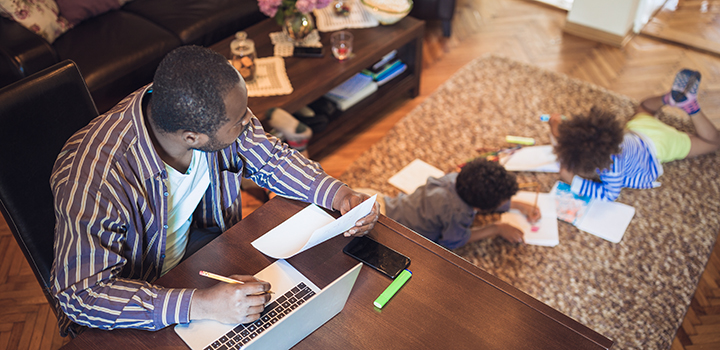 man with two young kids working at home