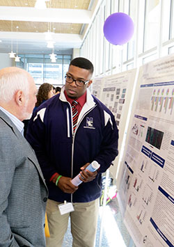 Two men discussing a poster