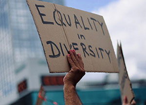 Protester holding up sign that says equality in diversity.