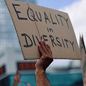 Protestor holding up sign that says equality in diversity.