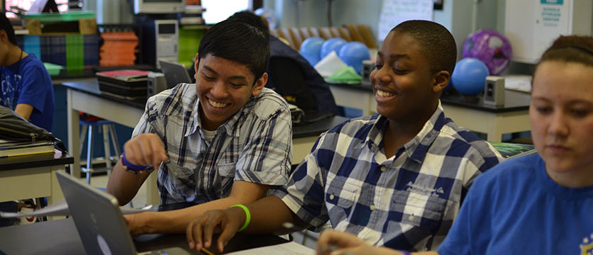 Image of students laughing in a classroom.