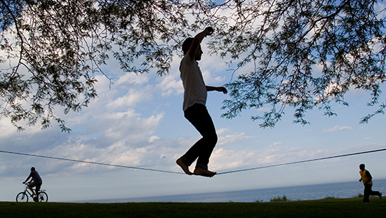 student walking on a tightrope in a park