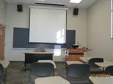 View of projection screen, podium in front of room.