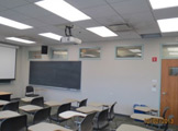 Wall/ceiling view: projector, florescent lights, projection screen and blackboard.