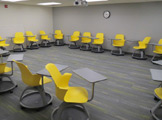 Chairs with built-in desks, arranged in room