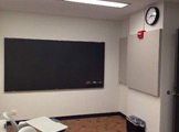 A picture of the chalboard and clock hung on the wall