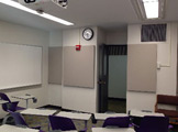 Picture of purple chairs and white board and view of the door
