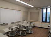Whiteboard with white chairs