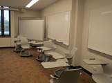Three white boards in a row with white chairs