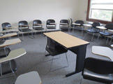 another view of locy hall room number 303 showing a desk and chairs