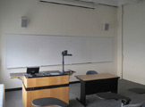 Photo of locy hall room number 318 showing podium and whiteboard