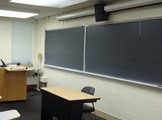 Blackboard and table in front of room.