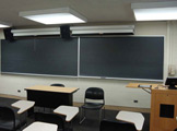 View of blackboard and podium at the front of the classroom.