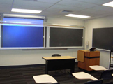 3 blackboards, podium and desk