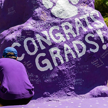 student signing their name at the rock