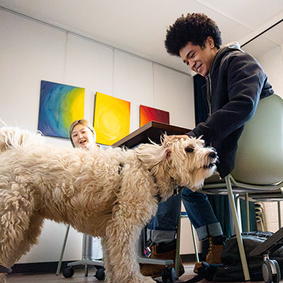 student petting dog