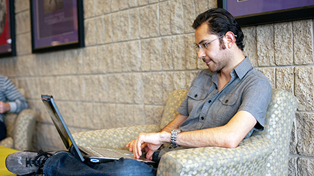 student looking at laptop on campus