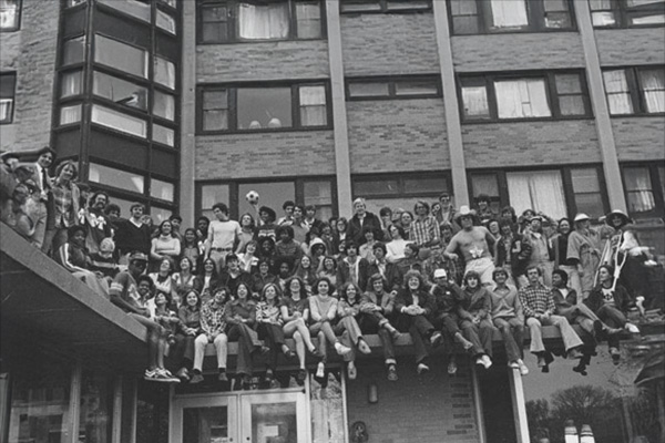 students sitting on building wall