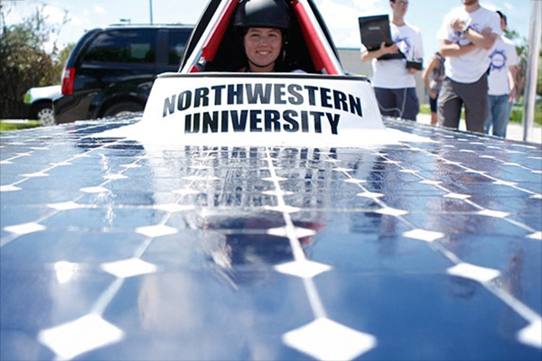 student sitting in a solar car