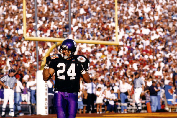 football players standing on the field with crowd behind him
