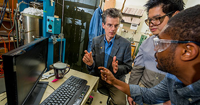 Students in a lab talking to a professor