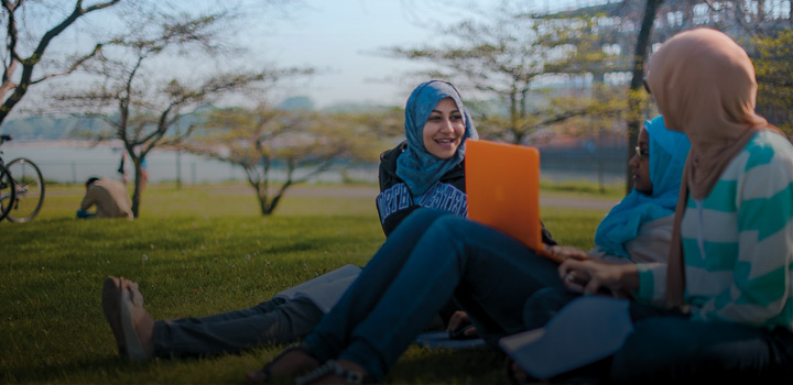 students with a laptop on the lakefront