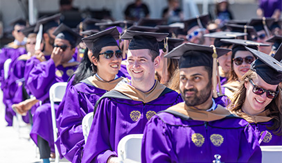 students in cap and gown seated for 2021 commencement