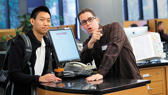 Photo of Library staff helping a student