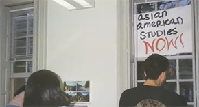 Two people in front of a sign that says "Asian American Studies now"