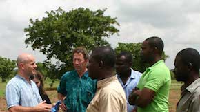 A group of people talking on open land 