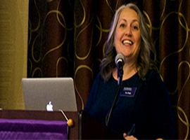 Kim Rapp speaking at the podium at an One World One Northwestern event