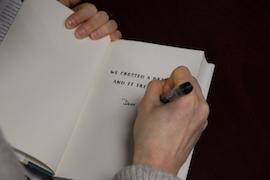 Wendy Pearlman signs one of her books for an attendee of the talk.