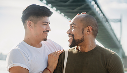 two guys looking at each other with bridge in background